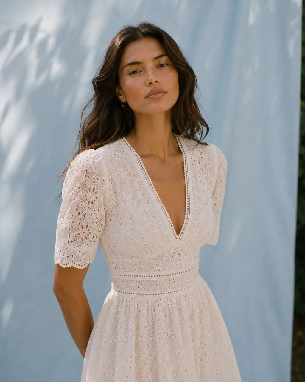 Close-up of an ivory eyelet petite dress with scalloped sleeve detail.